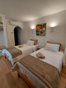 2 letti in una camera con un dipinto sul muro di Hostel Rosa a São Pedro de Muel