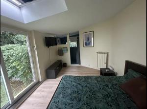sypialnia z łóżkiem i dużym oknem w obiekcie Chambre avec salle de bain et terrasse dans un maison chaleureuse w mieście Nanterre