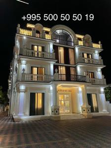 a large building with a lit up facade at night at DADIANI Inn in Zugdidi