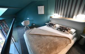 a bedroom with a large bed with blue walls at La Suite Appart Hôtel in Roanne
