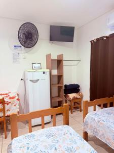 a room with a refrigerator and a tv on the wall at Pousada ENCANTOS DO MAR in Ubatuba +26 photos