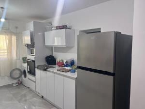 阿什杜德Ashdod big 5 Rooms for 10 people的厨房配有黑冰箱和白色橱柜。
