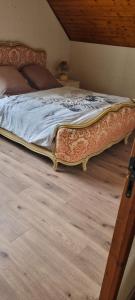 Villers-Robertchambre dans villa的卧室内的一张大床,铺有木地板