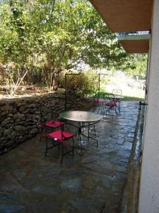 コルテにあるRésidence Talkinon - Saint Pancraceの石壁のパティオ(テーブル、椅子付)