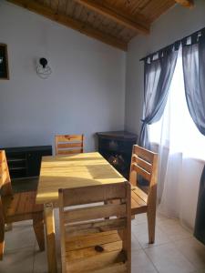 里奥格兰德Temporario RG的一间带木桌和椅子的用餐室以及窗户。