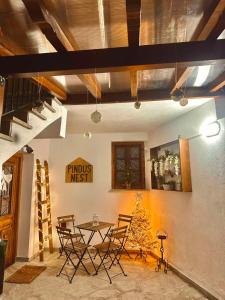 a dining room with a table and chairs and a christmas tree at Pindus Nest in Metsovo