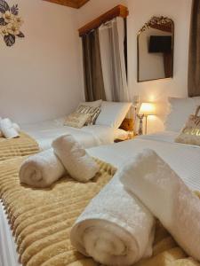 a hotel room with two beds with towels on them at Pindus Nest in Metsovo +17 photos