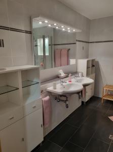 ein Badezimmer mit zwei Waschbecken und einem großen Spiegel in der Unterkunft Chambre D'hôtes - Les Hirondelles in Mirabel-aux-Baronnies