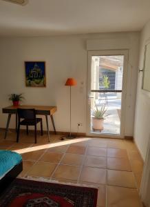 ein Wohnzimmer mit einem Tisch und einem Fenster in der Unterkunft Chambre D'hôtes - Les Hirondelles in Mirabel-aux-Baronnies