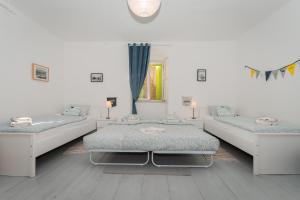 a white room with two beds and a mirror at Stone house Olsavinia close to the beach in Kaštela