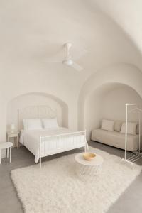 um quarto branco com uma cama e uma mesa em Unique small stonehouse at Thira em Megalokhori