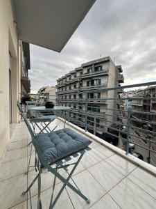 una sedia sul balcone di un edificio di Central stay a Larisa