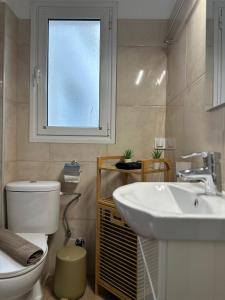 un bagno con un water, un lavandino e una finestra di Central stay a Larisa Altre 8 foto