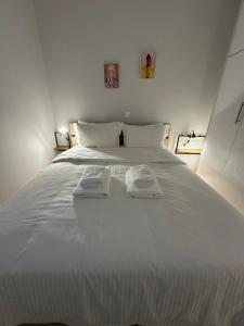 un letto bianco con due asciugamani sopra di Central stay a Larisa