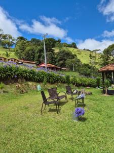 a group of chairs sitting in the grass at Chalé 01 maritacas in Cunha
