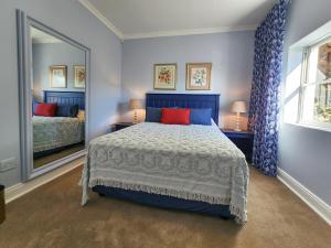 una camera da letto con un letto e un grande specchio di Living Lagoon Two Apartments a Brenton-on-Sea Altre 51 foto