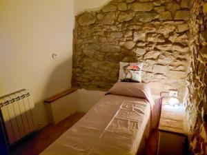 a bedroom with a stone wall with a bed in it at La Dimora di Dida in Seggiano +29 photos