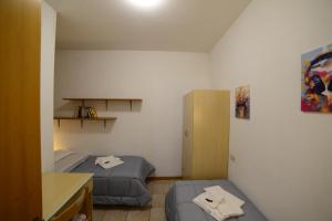a small room with two beds and a desk at A Due Passi dal Popolo in Ascoli Piceno