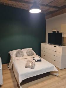ein Schlafzimmer mit einem Bett, einer Kommode und einem Fernseher in der Unterkunft Piernikowy Strumyk in Toruń