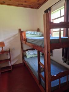 two bunk beds in a room with a window at Chalé 01 maritacas in Cunha