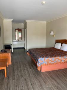 a hotel room with a bed and a desk at Crystal Inn - NASA Webster in Webster