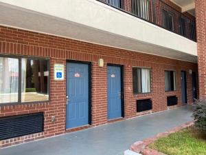 a brick building with two blue doors on it at Crystal Inn - NASA Webster in Webster