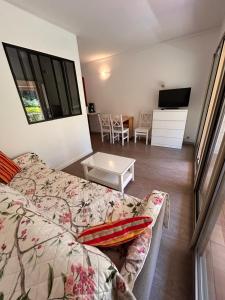 ein Wohnzimmer mit Sofa und Tisch in der Unterkunft Le Nid du Vallon -studio- Plage & Piscine in Sanary-sur-Mer