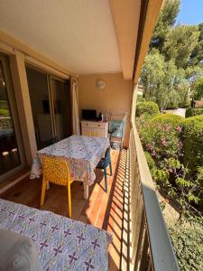 eine Terrasse mit Tisch und Stühlen auf einem Balkon in der Unterkunft Le Nid du Vallon -studio- Plage & Piscine in Sanary-sur-Mer