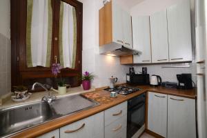 a kitchen with white cabinets and a sink and a stove at A Due Passi dal Popolo in Ascoli Piceno