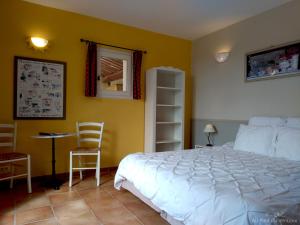 ein Schlafzimmer mit einem Bett, einem Tisch und Stühlen in der Unterkunft AU PIED DU VENTOUX in Flassan