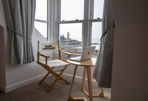 een bureau met een laptop en een stoel voor een raam bij Moir Cottage in Portpatrick