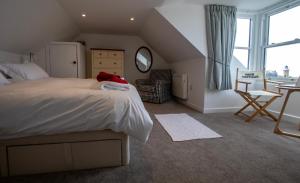 een slaapkamer met een bed, een tafel en een stoel bij Moir Cottage in Portpatrick