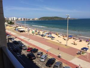a view of a beach with cars and umbrellas at Apartamento Guarapari Luxo Frente para o Mar in Guarapari