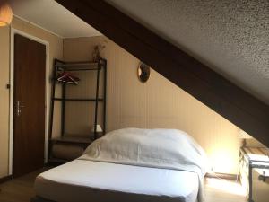 ein Schlafzimmer mit einem weißen Bett mit einem Holz in der Unterkunft Vaste appartement de montagne in Métabief