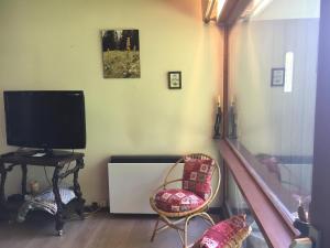 ein Wohnzimmer mit Flachbildfernseher und Stühlen in der Unterkunft Vaste appartement de montagne in Métabief + 34 Fotos