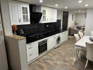 Una cocina con gabinetes blancos y encimeras negras. en Appartement, en Oberschaeffolsheim