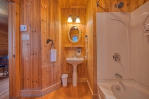 a bathroom with a sink and a bath tub at Chalet Saumon with Private SPA for 16 Guests , Skiing in Saint-Paul-de-Montminy +32 photos