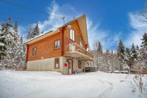 a large wooden house in the snow with trees at Chalet Saumon with Private SPA for 16 Guests , Skiing in Saint-Paul-de-Montminy