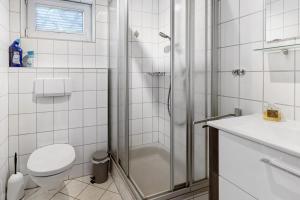 un bagno bianco con doccia e WC di Ferienwohnung Im Bohrer a Donaueschingen Altre 9 foto