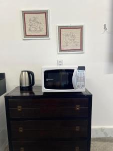 a microwave sitting on top of a dresser at Oásis House in Macau