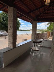 a table and chairs on a patio with a beach at Oásis House in Macau