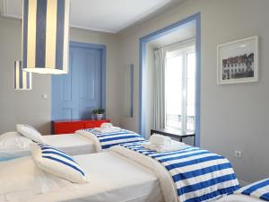 um quarto com três camas e uma janela em Combro by Patio 25 em Lisboa