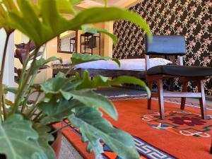 Una habitación con una cama y dos sillas y una planta. en Spacious Traditional Room with Boudha Stupa View, en Katmandú