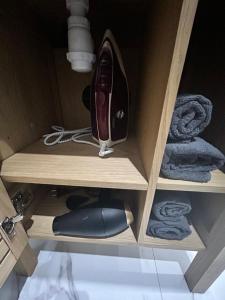 a wooden cabinet with a iron and towels at Jungle house,Arr autonome,Proche Aéroport & Gare in Beauvais