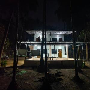 uma casa na floresta à noite em Shraddha Cottage em Nagaon