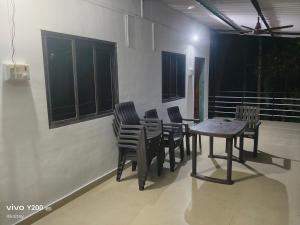 uma mesa e cadeiras de sala de jantar em um quarto em Shraddha Cottage em Nagaon