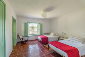 una camera da letto con due letti, una scrivania e una finestra di 188 - Quinta da Sobreda a Monte da Formiga Altre 55 foto