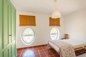 a bedroom with a bed and two windows at 188 - Quinta da Sobreda in Benavente