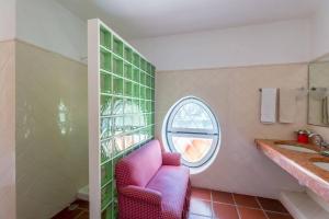 a bathroom with a pink chair and a window at 188 - Quinta da Sobreda in Benavente