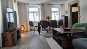 a living room with a television and a table with chairs at Ferienwohnung Hugos Altstadt in Pirna